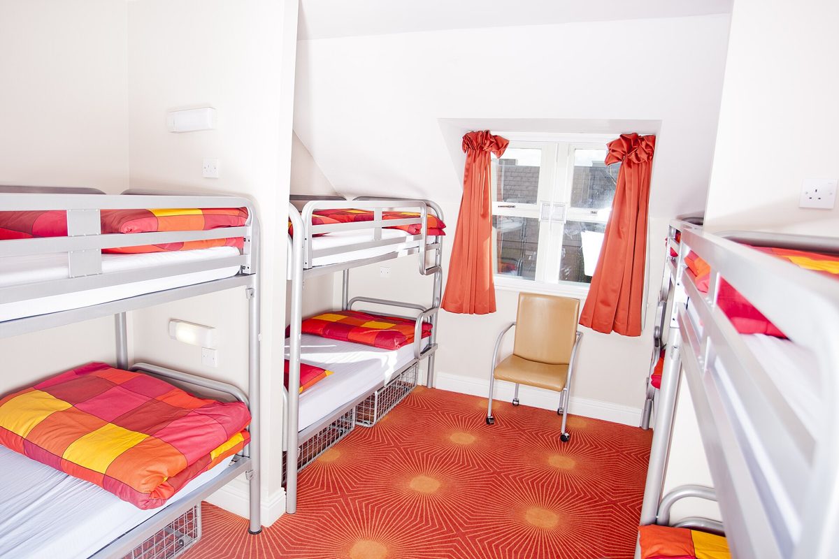 Bunk beds in a bright backpacker hostel dorm room