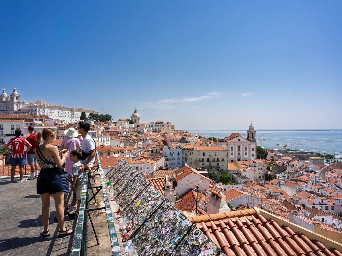 View over Alfama's terracotta rooftops to the Tagus River from a Lisbon miradouro