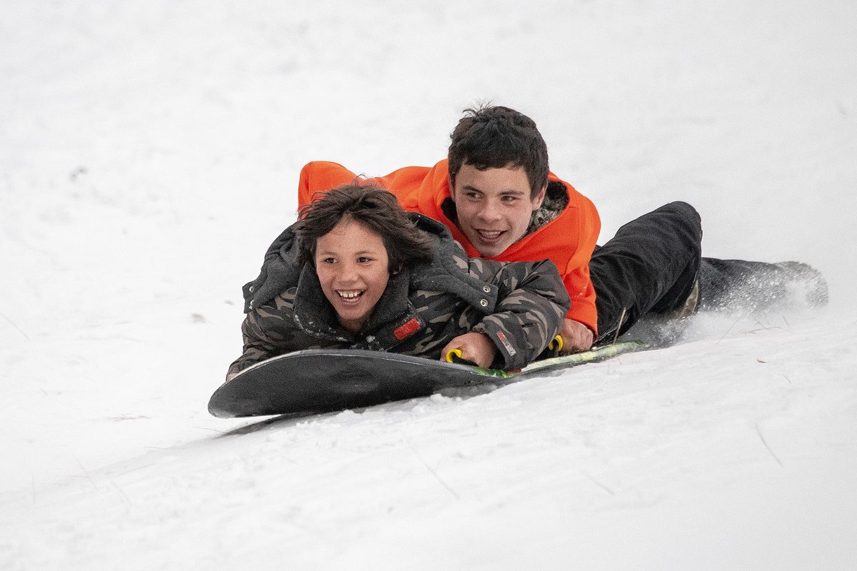 A family enjoying a day on the slopes together, skis on and smiling