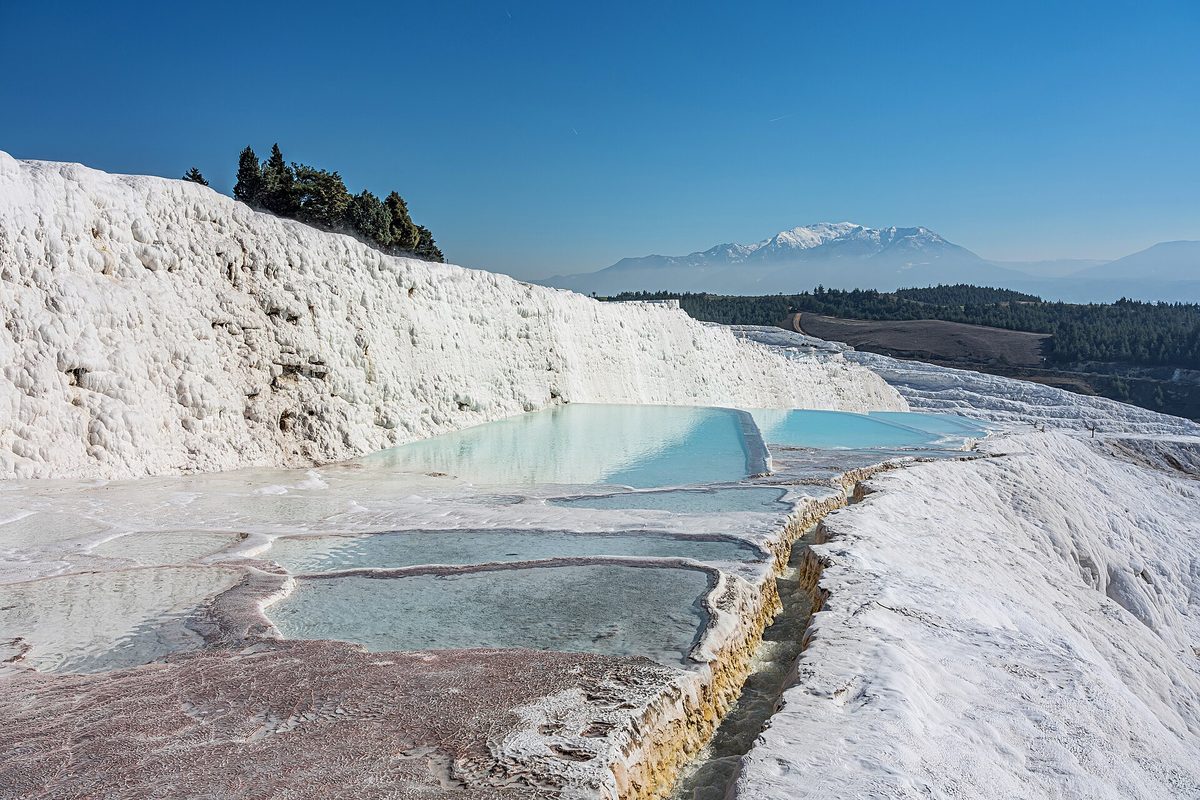 The white travertine terraces and blue pools of Pamukkale, Turkey