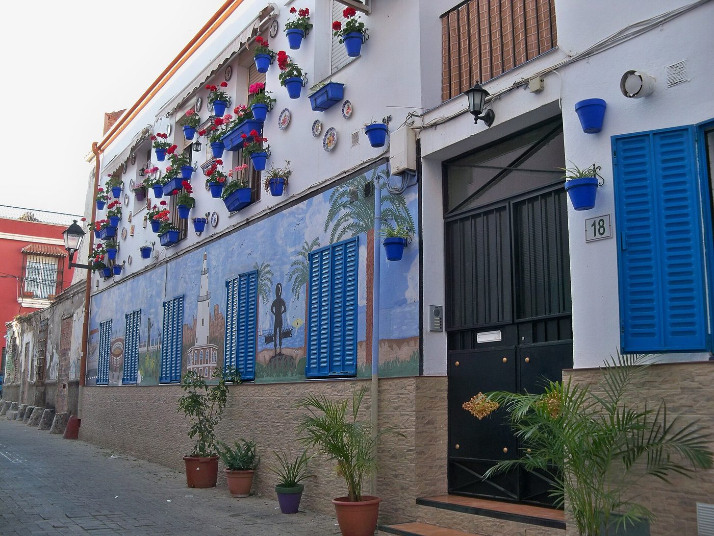Blue flower pots and painted tiles on a house front in the La Trinidad district of Malaga