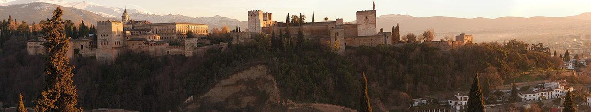 The Alhambra of Granada at sunset with the snow-covered peaks of the Sierra Nevada behind it