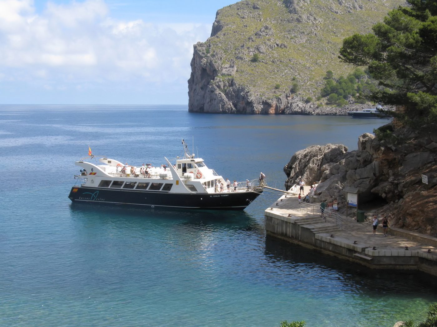 A tourist boat moored at Sa Calobra beneath the Tramuntana cliffs, Mallorca