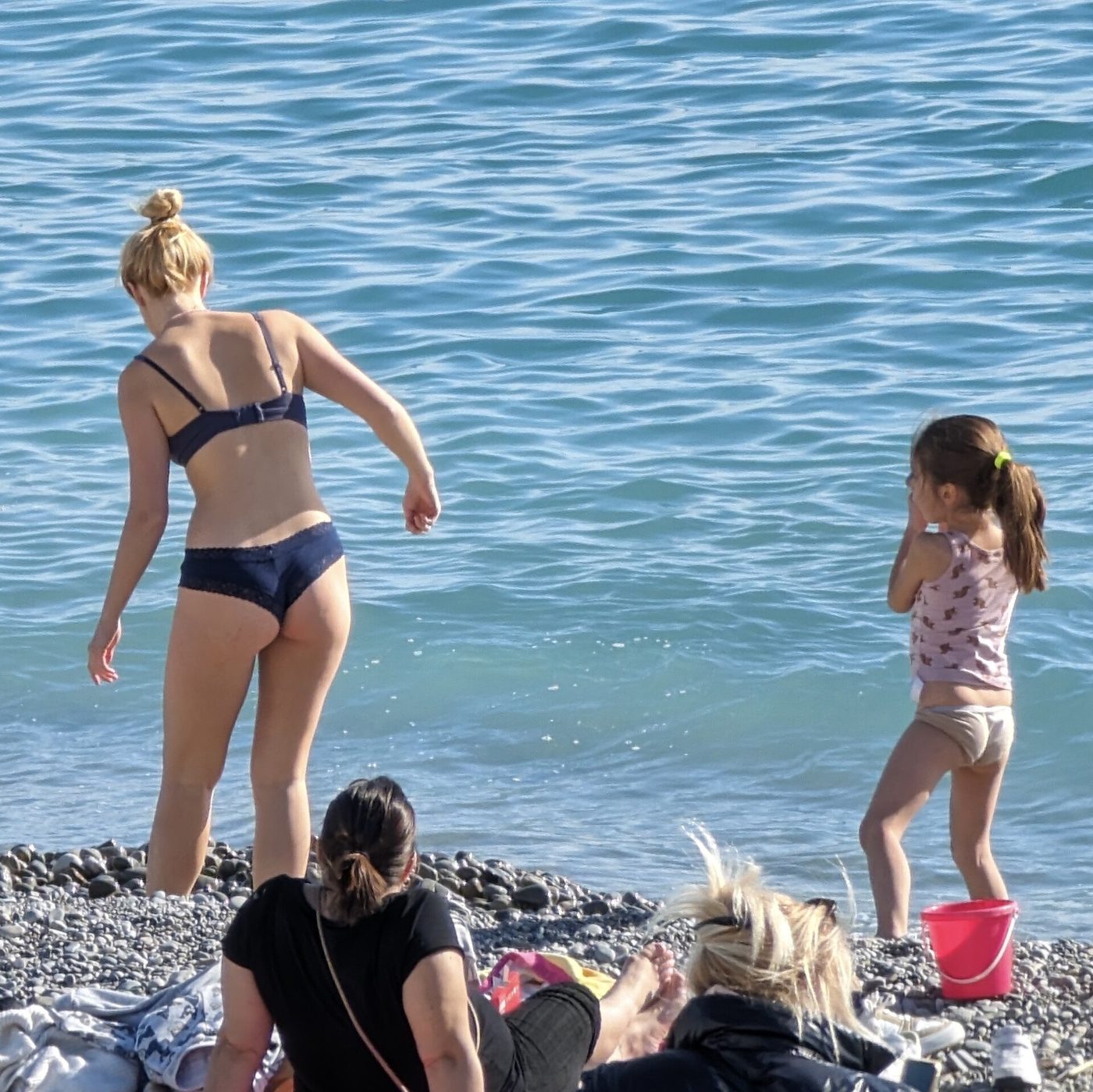 Swimmers on the pebble beach below the Promenade des Anglais in Nice