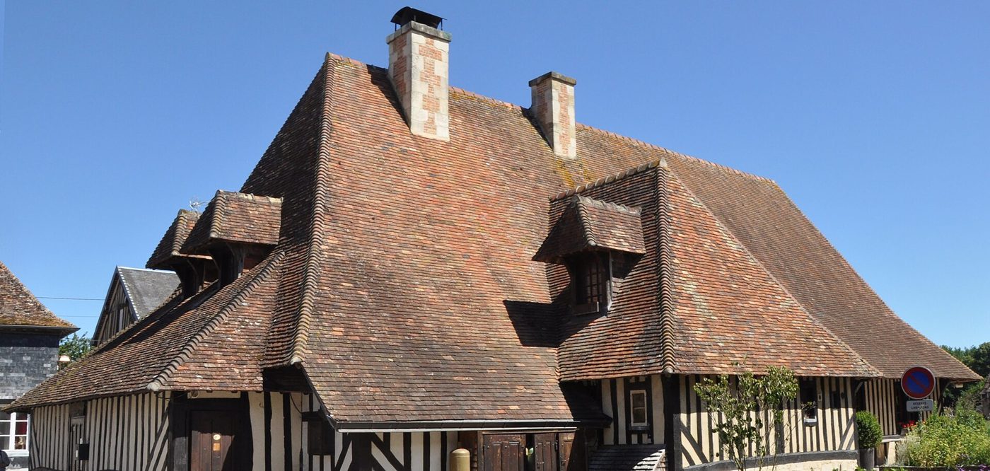 A half-timbered house with a steep tiled roof at Beuvron-en-Auge in the Pays d Auge
