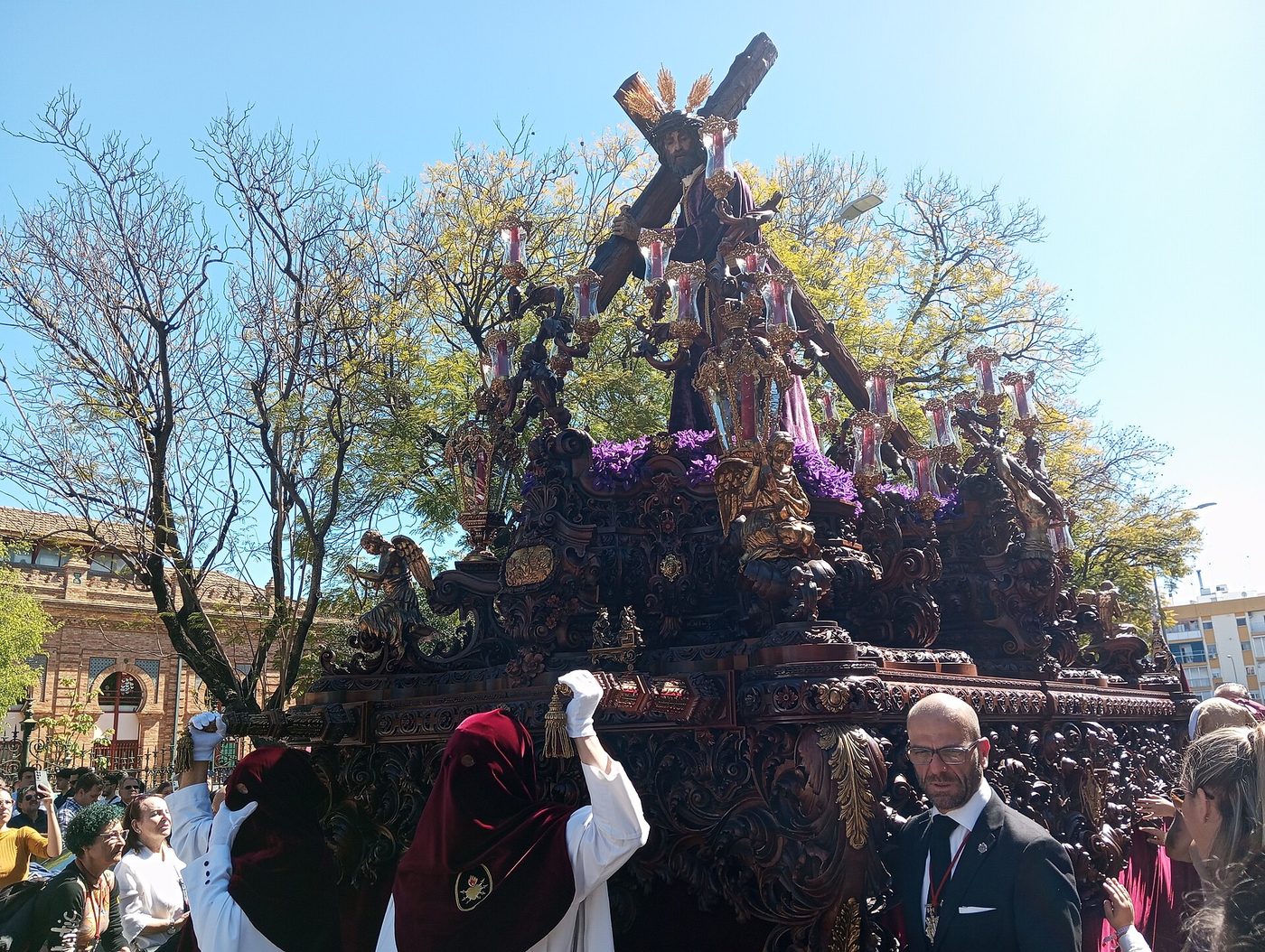 A Semana Santa paso carried through a crowded street in Seville