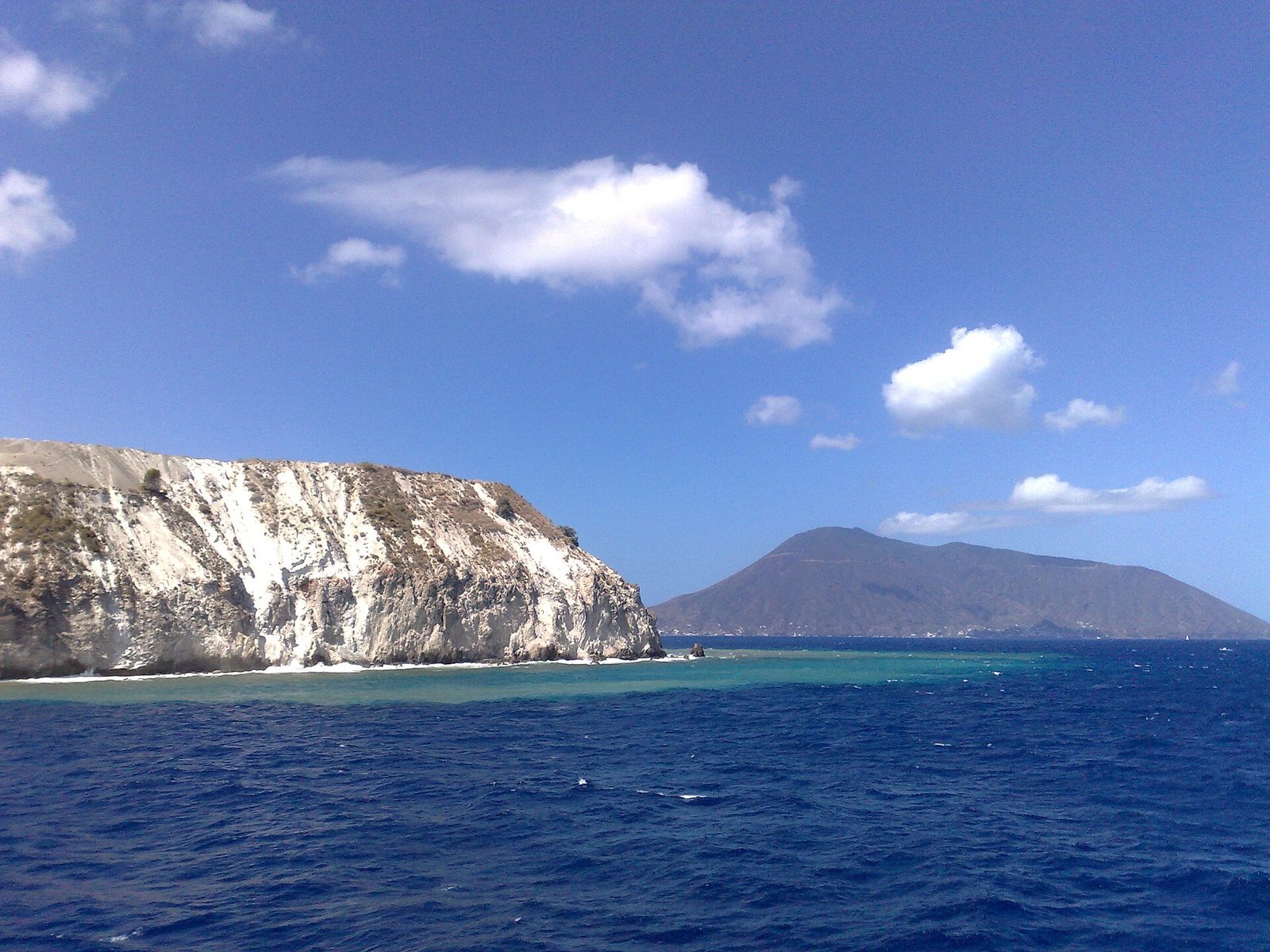 The white pumice cliffs of Lipari with another Aeolian island on the horizon