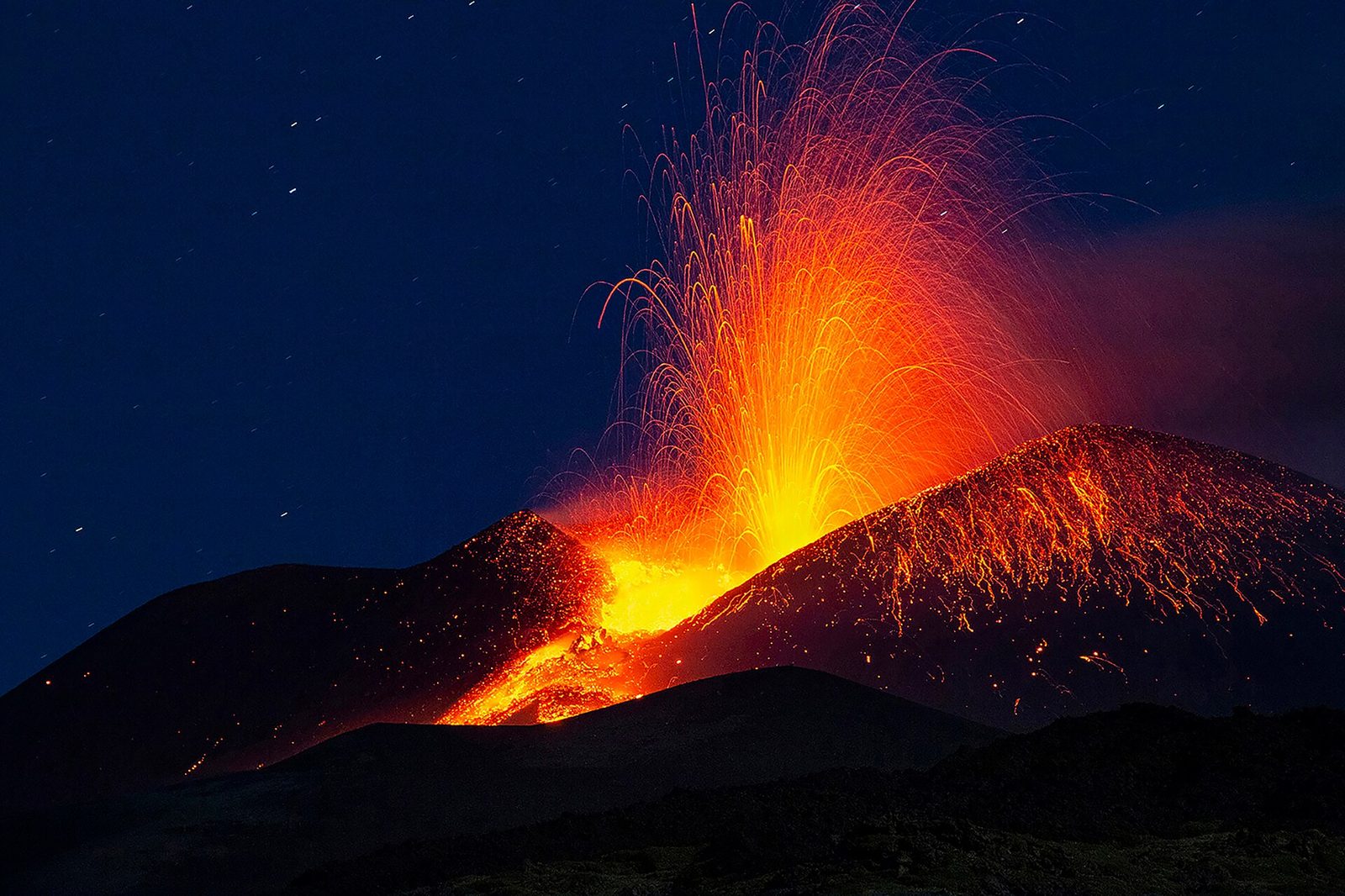 Lava fountaining from a crater on Mount Etna at night, Europe's most active volcano