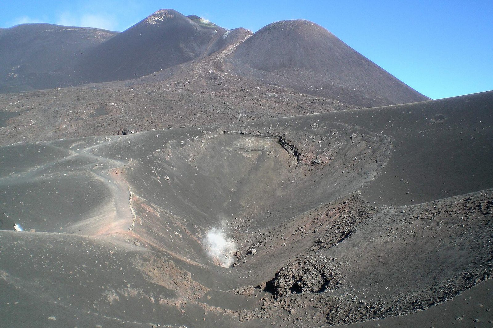 Black ash and a crater rim high on the flank of Mount Etna in Sicily