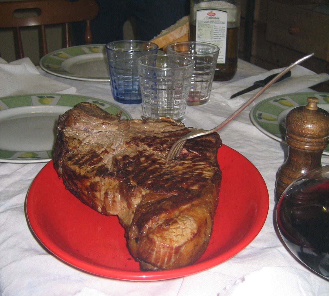 A bistecca alla fiorentina, the thick-cut Tuscan T-bone, served rare on the plate
