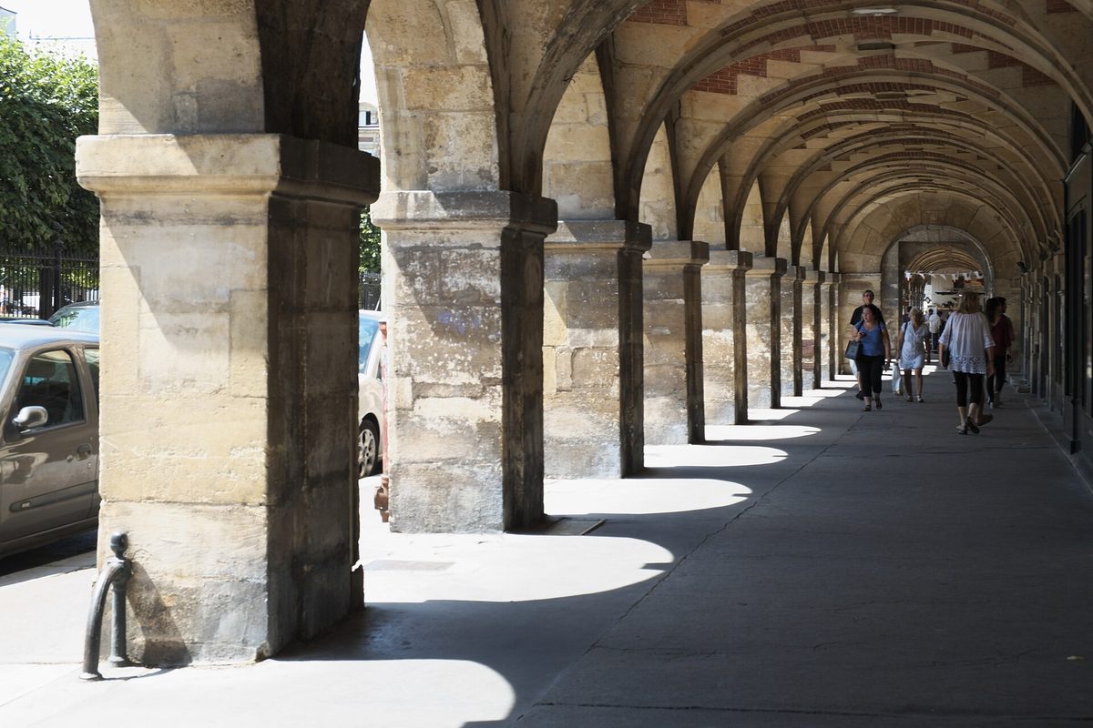 The stone arcades running around the Place des Vosges in the Marais district of Paris