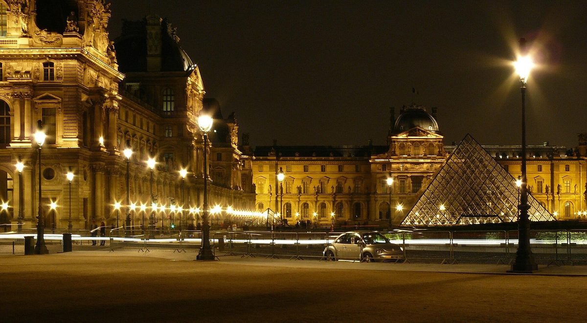 The glass pyramid lit at night in the courtyard of the Louvre, one of the top things to do in Paris