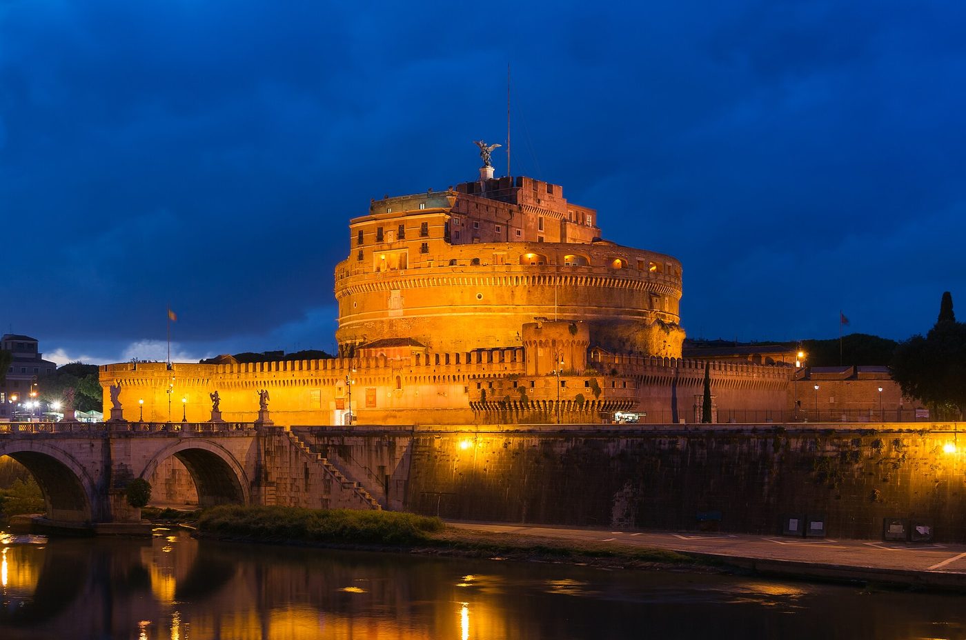 Castel Sant Angelo and the Ponte Sant Angelo lit at dusk over the Tiber in Rome