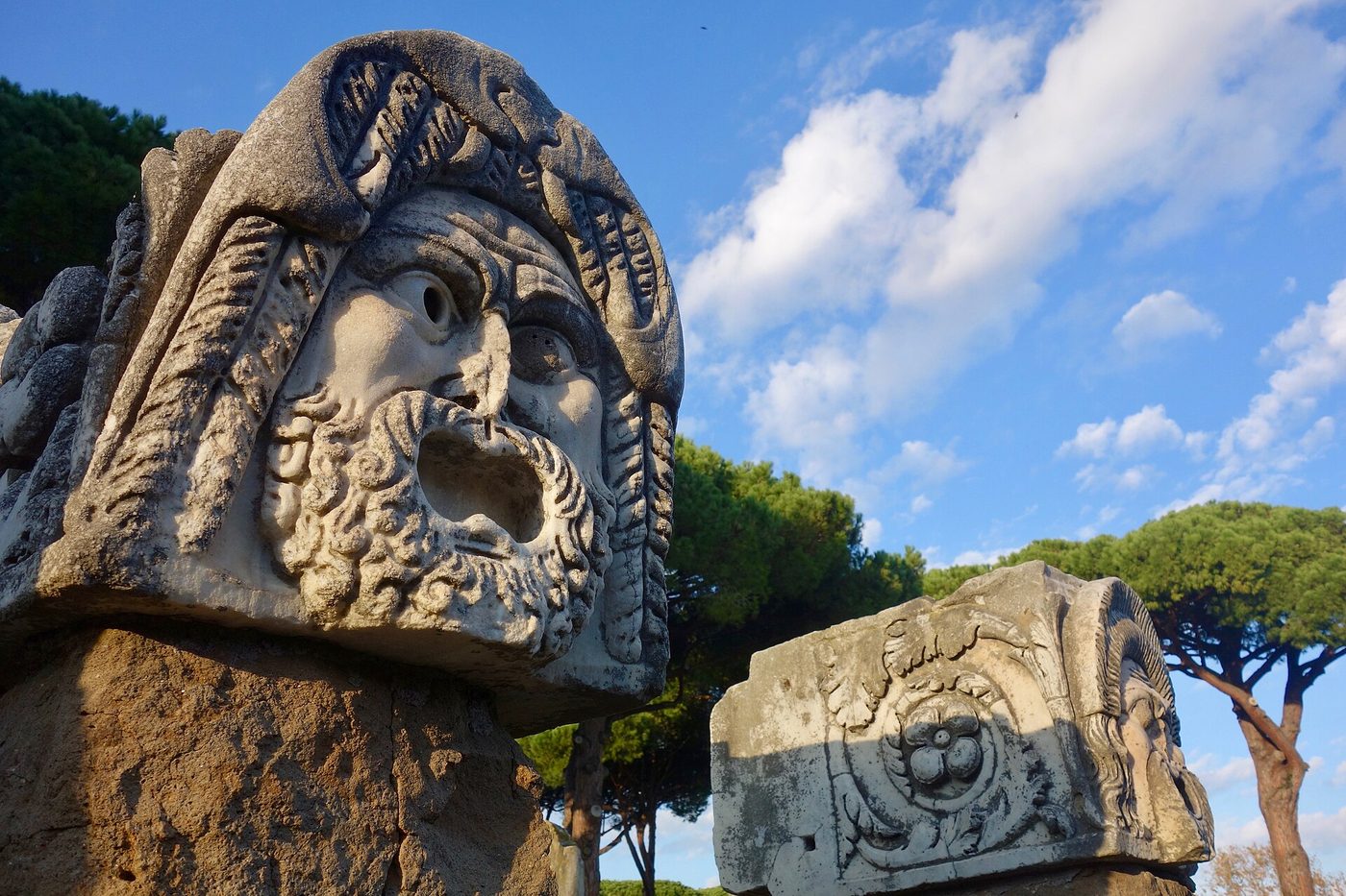 Carved theatrical masks at the archaeological park of Ostia Antica near Rome