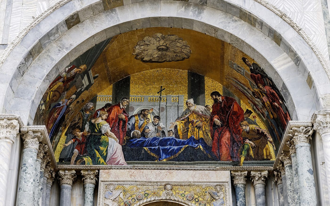 A gold mosaic lunette above a doorway on the facade of St Mark's Basilica in Venice
