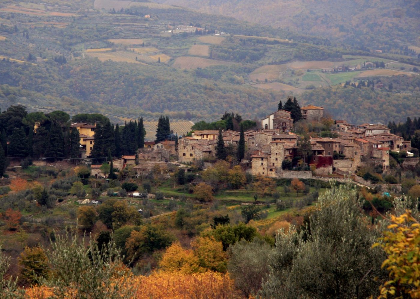 A stone hill village above vineyards in the Chianti hills of Tuscany
